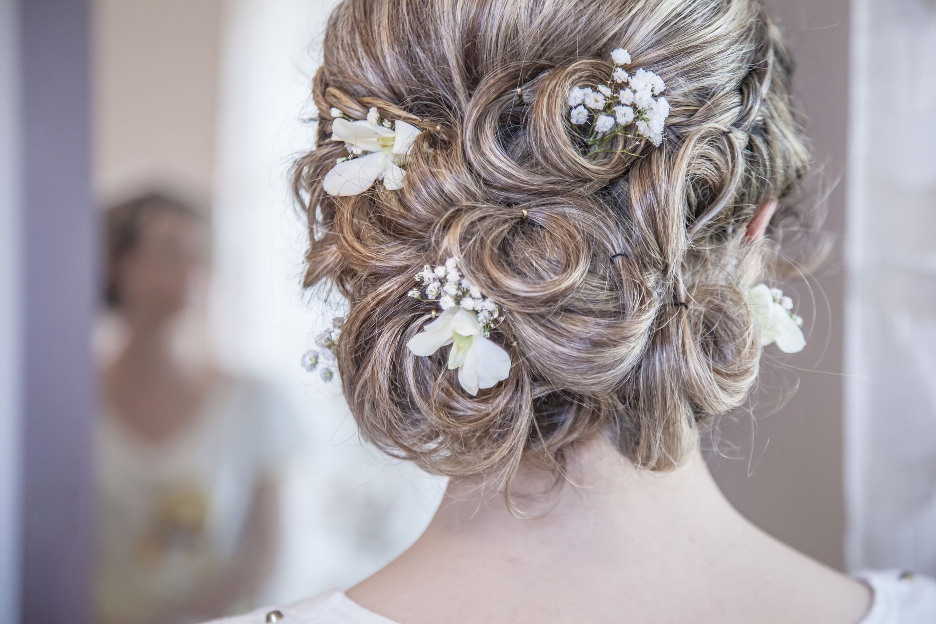 Chignon bouclé orné de petites fleurs blanches
