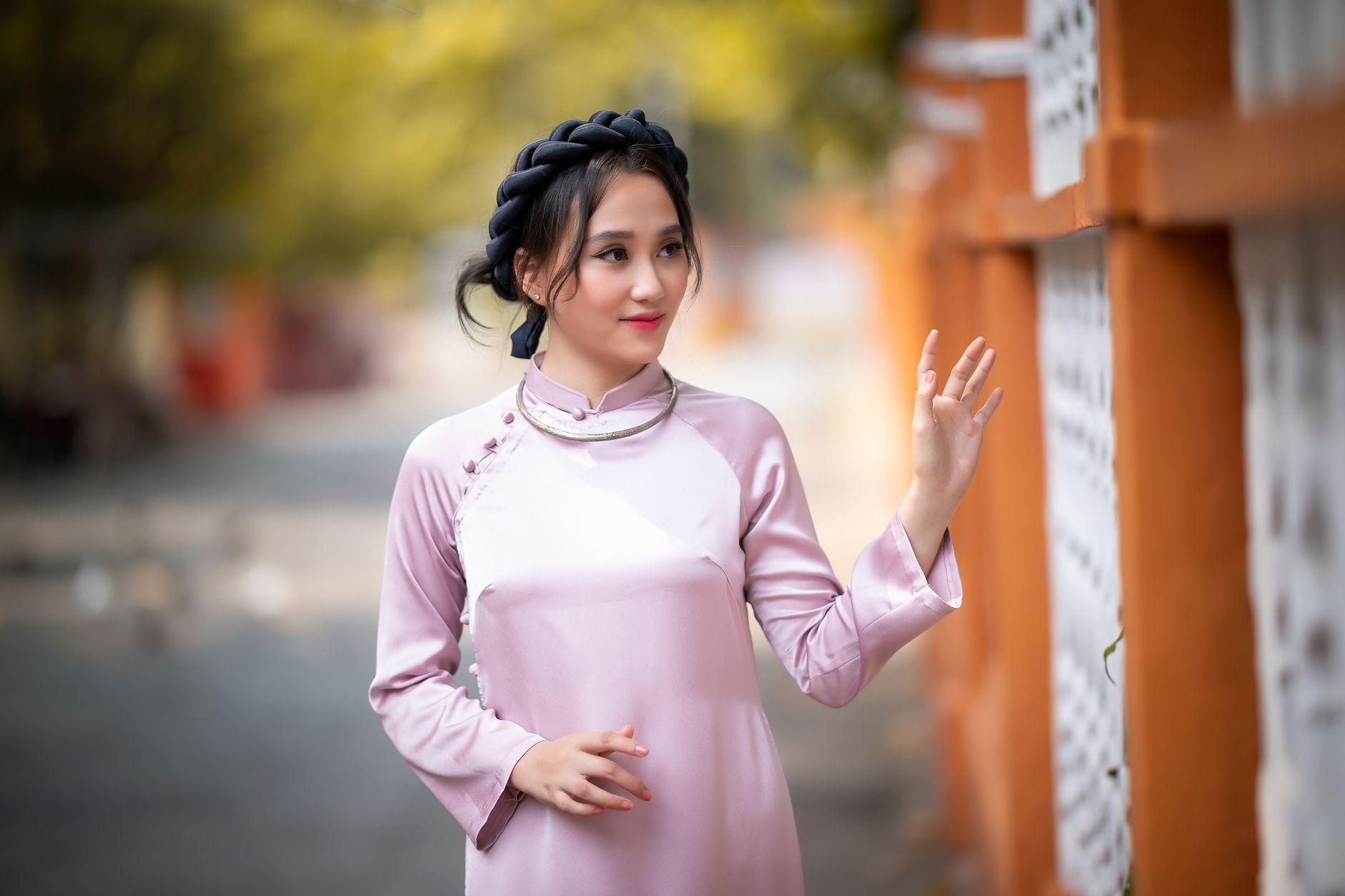Femme en robe de soie, cheveux coiffés, posant en ville